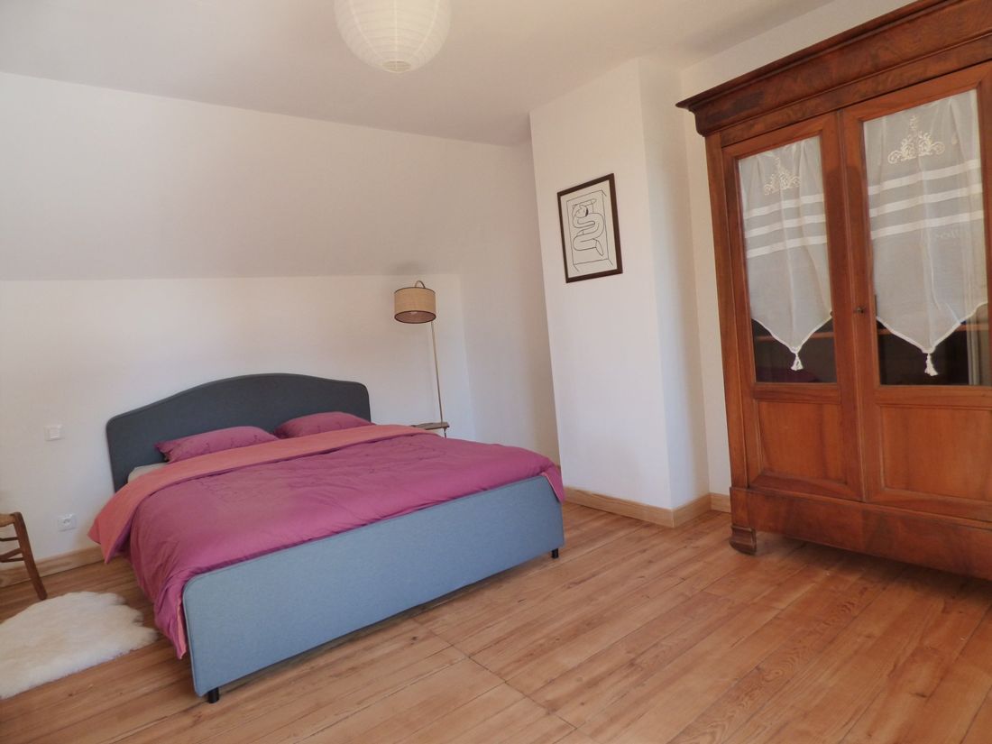 Chambre avec lit double et armoire ancienne