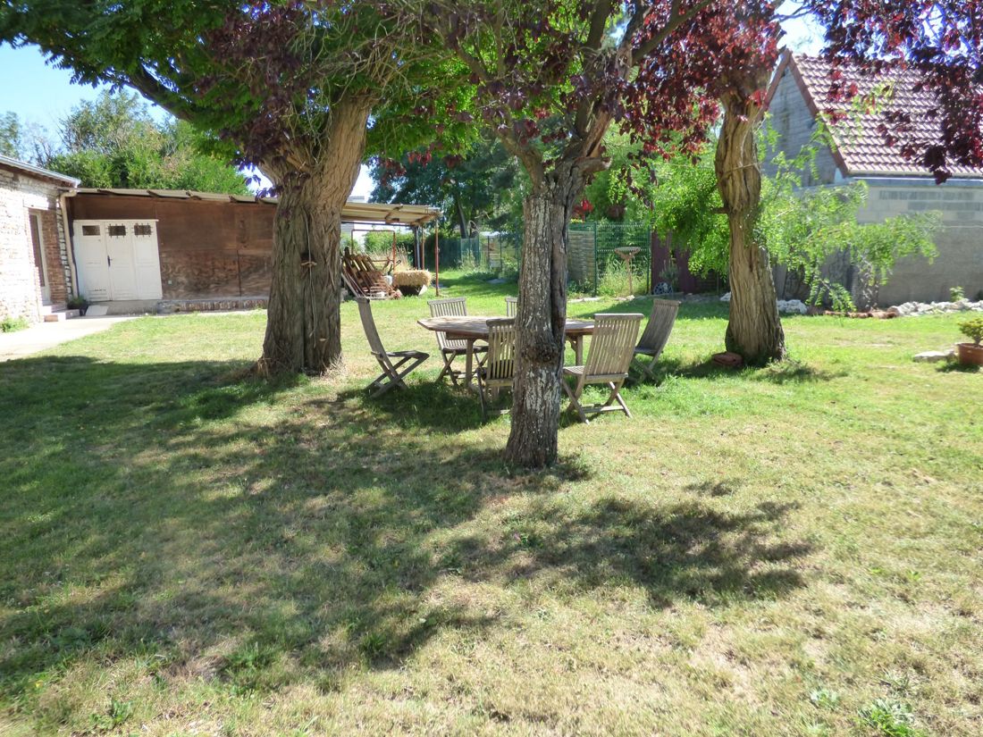 Table de jardin à l'ombre des arbres sur la pelouse